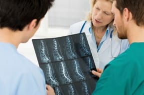 A team of doctors reviews an xray of a New Jersey spinal cord injury