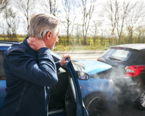 an Uber passenger with whiplash getting out of the car after a car traffic accident